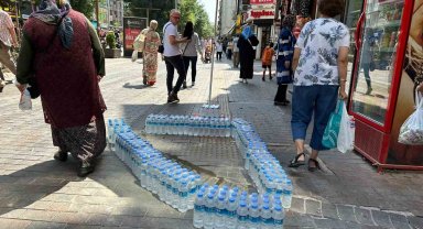 Kaldırımda beton döktüğü alanı su şişeleriyle çevreledi