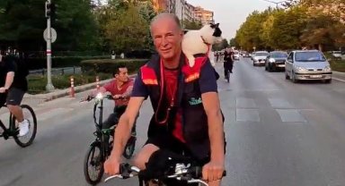 Omzunda kedisi ile bisiklete binip kutlama kortejine katıldı
